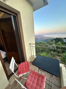 a balcony with two chairs and a table and a view at RASTONI Pelion in Vyzitsa