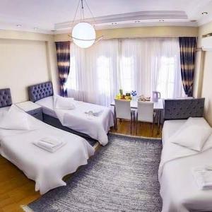 a room with two beds and a dining room with a table at Harun Fars in Yalova