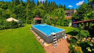 an overhead view of a swimming pool in a yard at Porumbacu Retreat-Cabana Forest A-frame și Chalet Max cu jacuzzi și piscină sezonieră, pe malul râului ,în apropiere de Transfăgărășan, Sibiu in Porumbacu de Sus