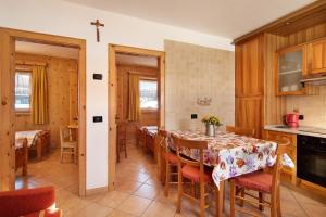 a kitchen and dining room with a table and chairs at Baita sulle Alpi Livigno in Livigno +12 photos
