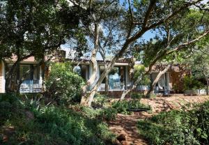 a house with trees in front of it at Leshiba Wilderness in Louis Trichardt