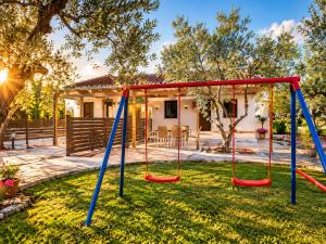 a swing set in the yard of a house at Chrisella Villa in Skala Rachoniou