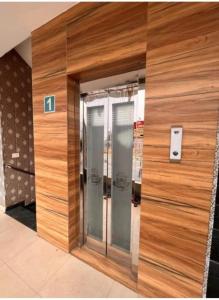 a wooden wall with three elevators in a building at Hotel PG Grand in Mohali
