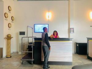 a man standing at a counter with a woman behind it at Corporate Residence in Port Harcourt