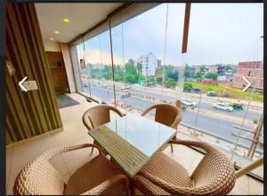 a table and chairs on a balcony with a view of a street at Hotel PG Grand in Mohali