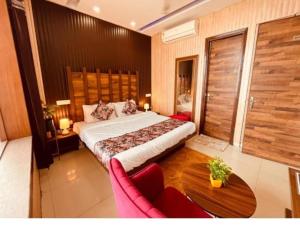 a bedroom with a large bed and a table at Hotel PG Grand in Mohali