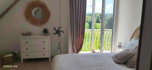 a bedroom with a bed and a mirror and a balcony at Gîte le temps d'un instant in Samer
