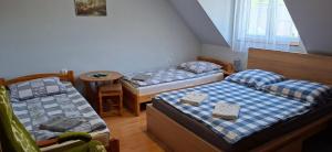 a room with two beds and a table in it at U Janusza in Zadwórze