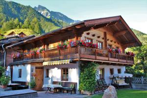 a house with a balcony with flowers on it at Stoanahof in Virgen