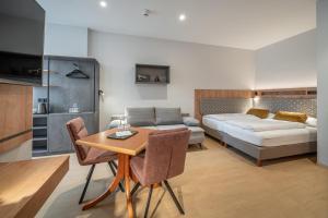 a room with a bed and a table and a couch at Hotel Neue Post I self check-in in Innsbruck