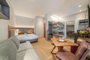 a hotel room with a bed and a couch and a table at Hotel Neue Post I self check-in in Innsbruck