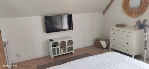 a bedroom with a bed and a tv on the wall at Gîte le temps d'un instant in Samer