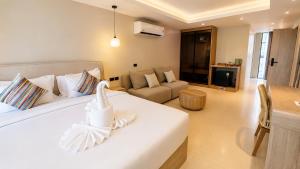 ein Schlafzimmer mit einem weißen Bett und einem Sofa in der Unterkunft ROZ MARINE Boutique Hotel in Bophut 