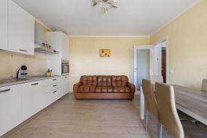 a living room with a brown leather couch in a kitchen at Da Dani Casa Vacanza in Pontremoli