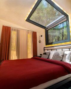 a bedroom with a large bed with a large window at Mossa Afkule Kayaköy in Fethiye