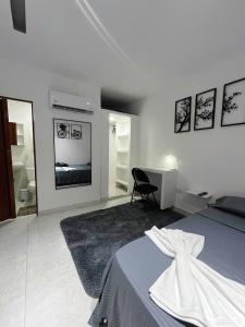 a white bedroom with a bed and a desk and a mirror at Apart Hotel miwi in Los Patios