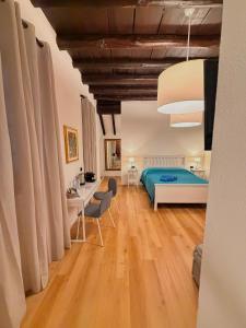 a bedroom with a bed and a desk and chairs at Villa Gianna affitta camere in Inverigo