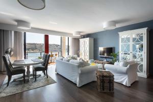 a living room with white couches and a table at St Angelo Mansions 3BDR flat with Seaview in Vittoriosa