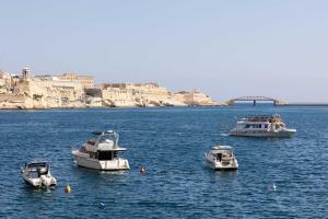three boats in a large body of water at St Angelo Mansions 3BDR flat with Seaview in Vittoriosa