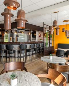 a restaurant with tables and chairs and a bar at Hotel de Gentsche Poort in Biervliet