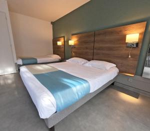 a large bed in a hotel room with two beds at Vent d'Eden Park Hôtel in Saint-Hilaire-de-Riez