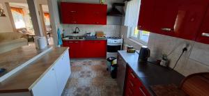 a small kitchen with red cabinets and a stove at U Janusza in Zadwórze