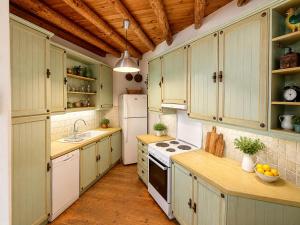 a kitchen with green cabinets and a white refrigerator at "GOLDEN SUNSET VILLA" 3-BDR, Breathtaking Views in Batsi +16 photos