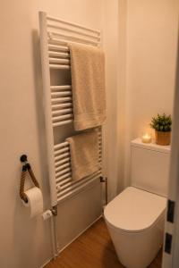 a bathroom with a toilet and towels and a candle at Ferienwohnungen Blischke in Carolinensiel +95 photos