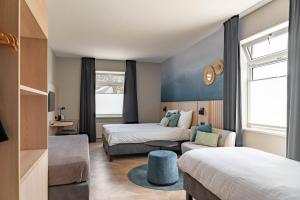 a hotel room with two beds and a couch at Hotel de Gentsche Poort in Biervliet +48 photos