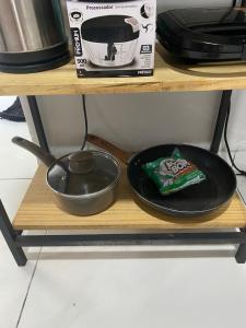 a pan and a bowl on a plate on a shelf at silencioso e aconchegante in Rio Verde