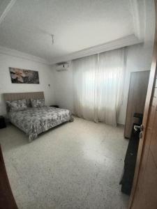 a bedroom with a bed and a window with curtains at galaxy home in Nabeul +12 photos
