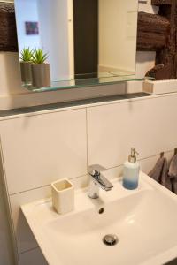 a bathroom sink with a mirror and a sink sidx sidx sidx at PrimeBnb Am Marktplatz in Bad Hersfeld