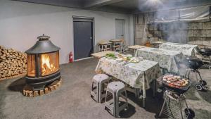 a room with a fireplace and tables and a fire grill at Chuncheon Lio Pension in Chuncheon
