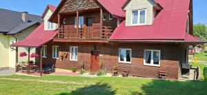 a large wooden house with a red roof at U Janusza in Zadwórze