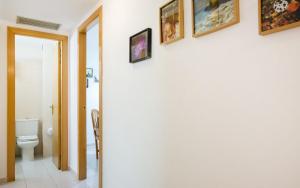 a bathroom with a toilet and pictures on the wall at Miquel 1 – Piso con Parking y Wifi en el Centro in Tossa de Mar +60 photos