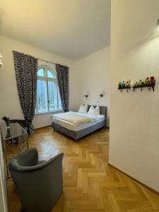 a bedroom with a bed and a chair and a window at Vila Popovici in Prăjila
