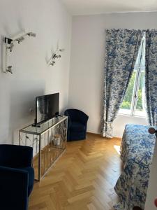 a living room with a tv and a bed and a window at Vila Popovici in Prăjila