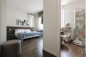 a white bedroom with a bed and a toilet at I Segreti della Valle in Agrigento