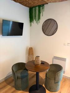 a living room with a table and two chairs at L'EVIDENCE Love Room & spa in Chaveignes