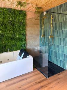 a bathroom with a white tub and a green wall at L'EVIDENCE Love Room & spa in Chaveignes +3 photos