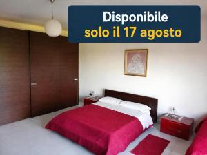 a bedroom with a large bed with a red blanket at Appartamento Perito in Perito