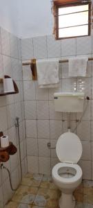 a bathroom with a white toilet and a window at Shalom Homestay in Kilindoni