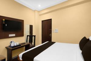 a bedroom with a bed and a tv on the wall at Townhouse Defence Colony Noida in Greater Noida +39 photos