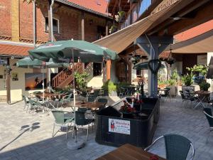 eine Terrasse mit Tischen, Stühlen und einem Sonnenschirm in der Unterkunft Hotel Sonnekalb in Naumburg + 22 Fotos