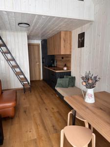 a living room with a table and a kitchen at Chata Slovena in Novoť