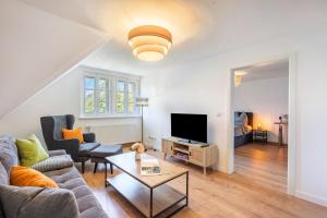 a living room with a couch and a tv at Villa Rathmannsdorf in Rathmannsdorf