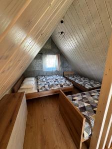 two beds in a attic room with wooden ceilings at Chata Slovena in Novoť