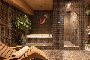 a bathroom with a shower and a tub with a plant at Residence Grünwald in Valles +40 photos