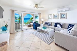 a living room with a couch and a table at Modern Beachfront Condo with Pool - Sapphire 307 in Christ Church
