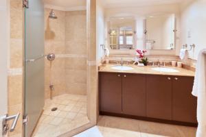 a bathroom with two sinks and a shower at Modern Beachfront Condo with Pool - Sapphire 307 in Christ Church +10 photos